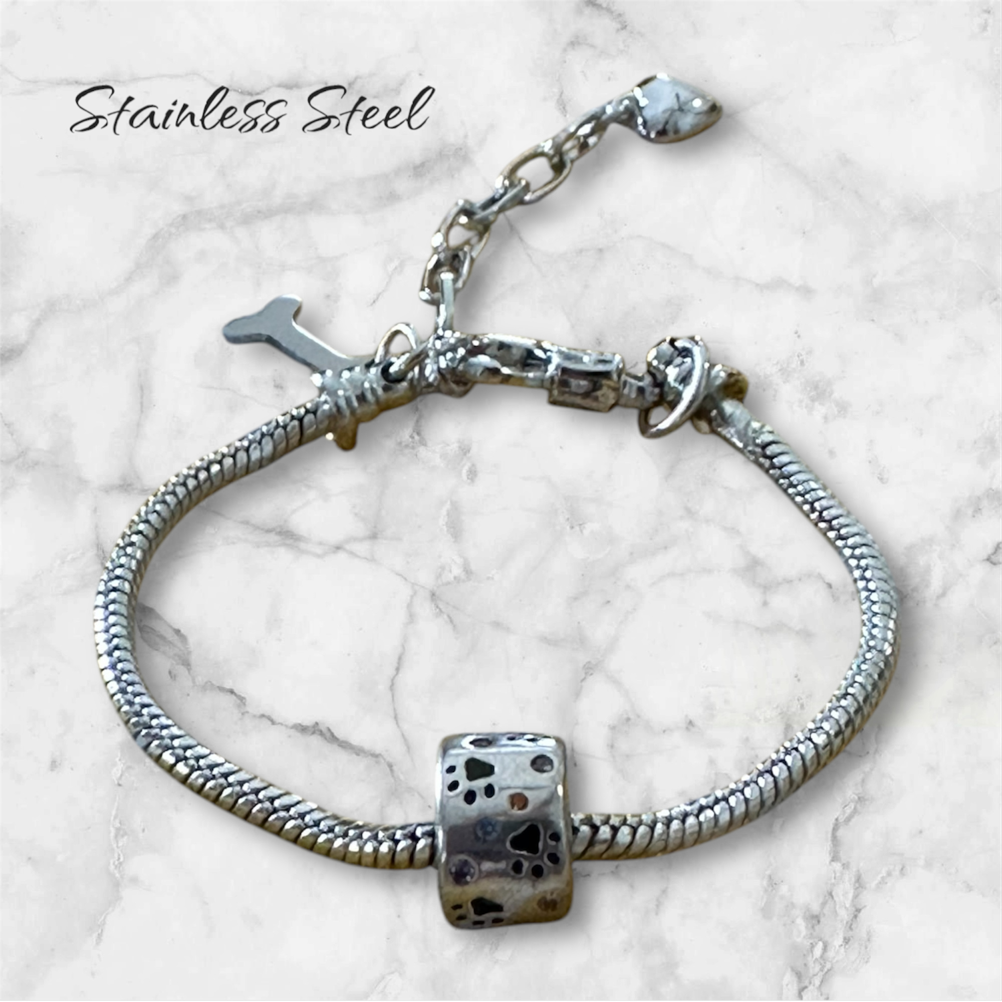 Pulsera plateada en acero inoxidable con dije de huellitas y corazones